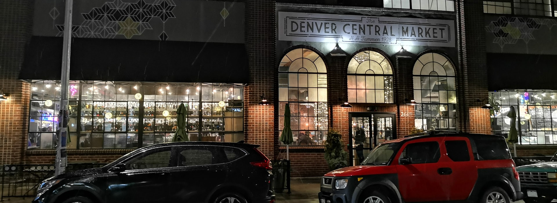 cars parked in front of Denver Central Market at night